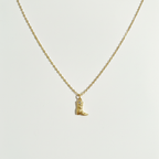 Cowboy boot necklace on white surface