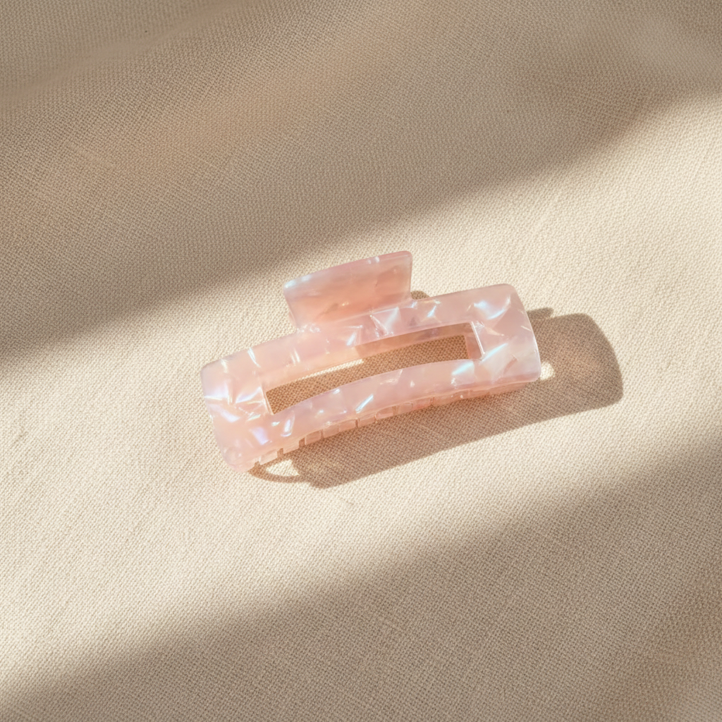 Pink iridescent rectangular hair claw clip on cream linen