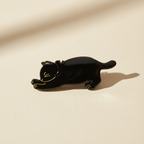 Black cat hair claw clip on warm ivory background