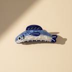 Large fish hair claw clip on warm ivory background