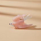 Bird hair claw clip on warm beige surface