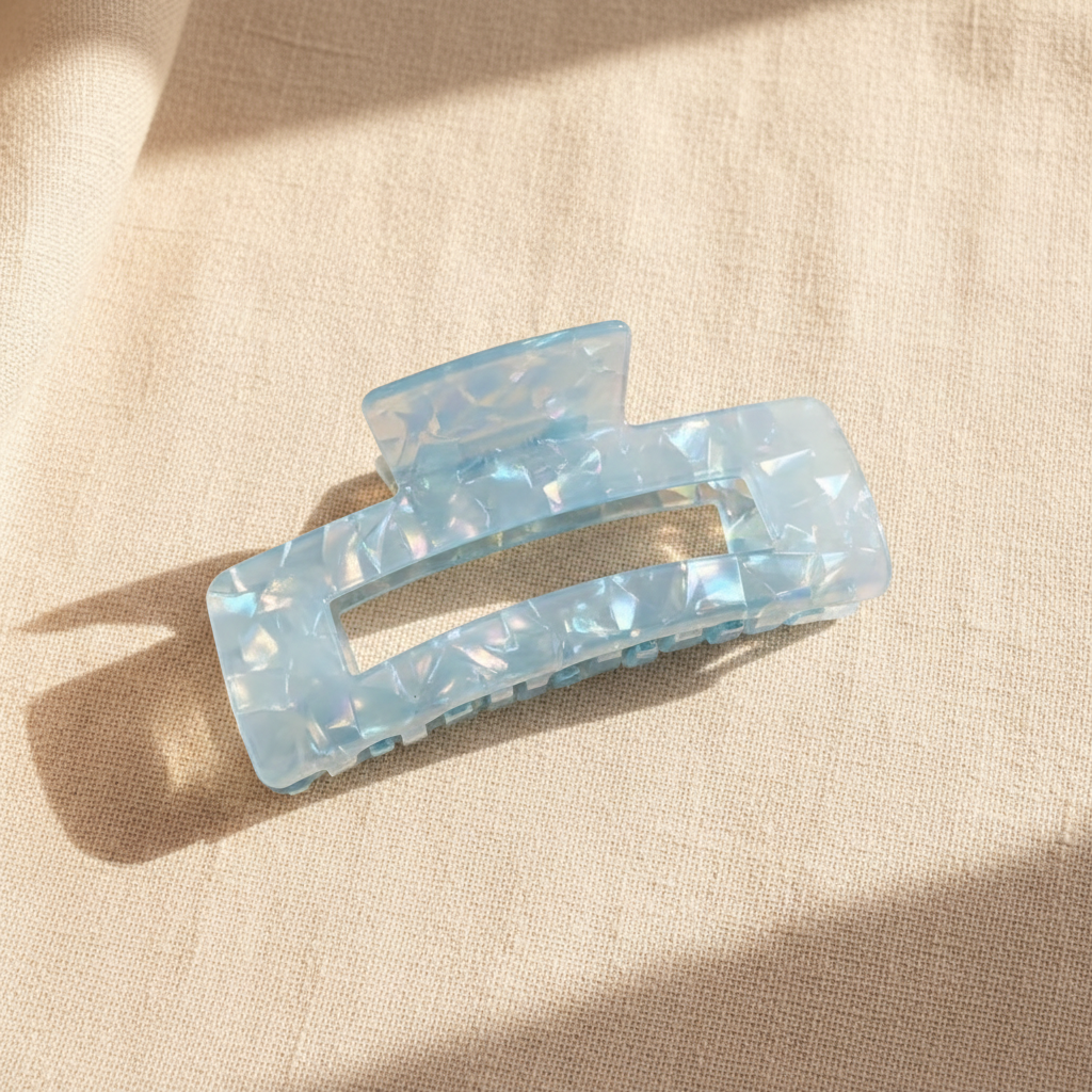 Blue iridescent rectangular hair claw clip on cream linen