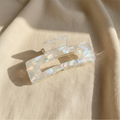 Clear iridescent rectangular hair claw clip on cream linen