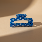 Cobalt blue evil eye hair claw clip on warm beige surface