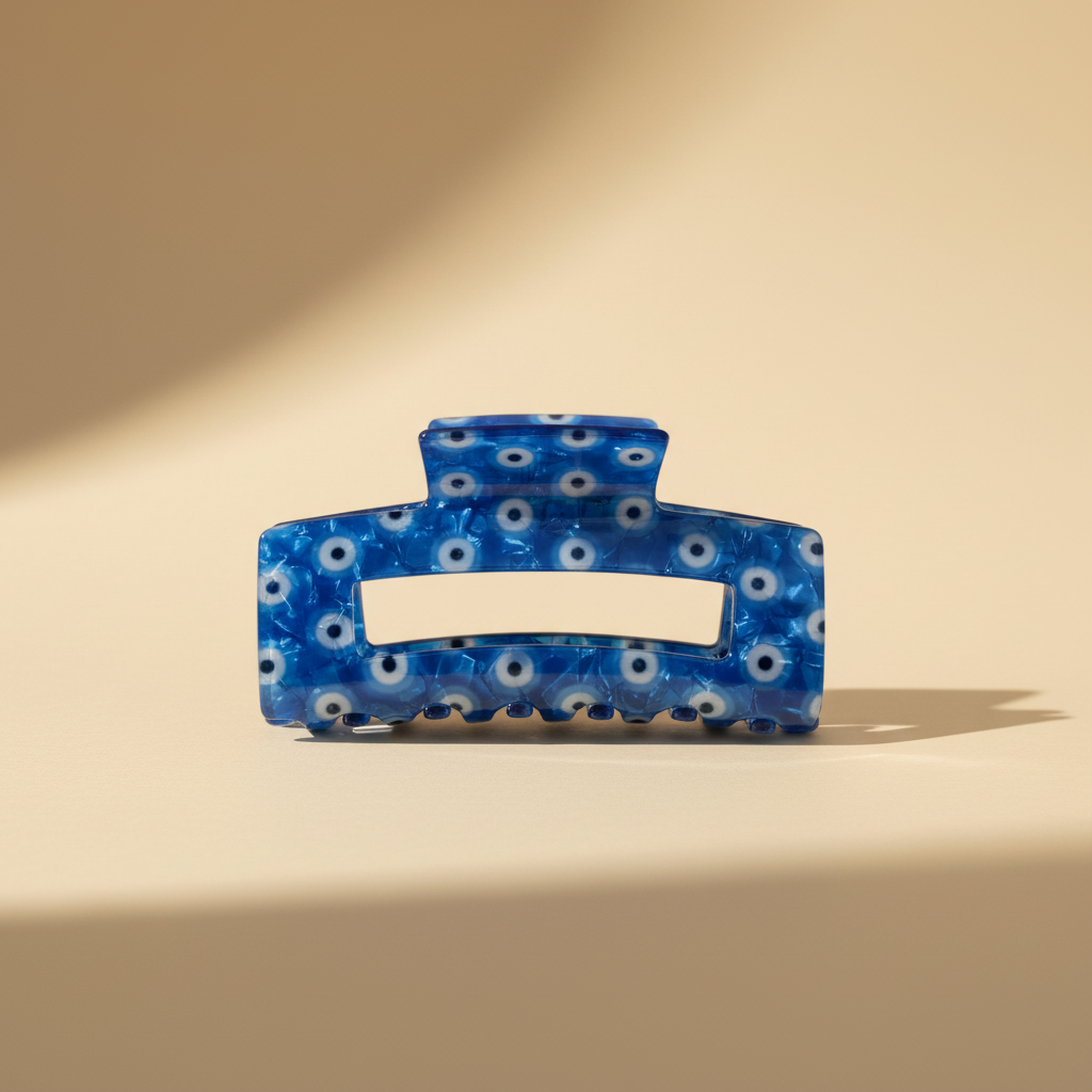 Cobalt blue evil eye hair claw clip on warm ivory background