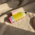 Yellow pencil hair clip on linen with sunlight