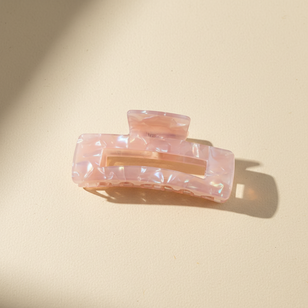 Pink iridescent rectangular hair claw clip on warm ivory background