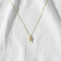 Middle finger necklace on linen