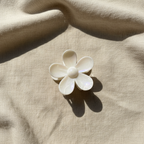 White flower clip on beige linen